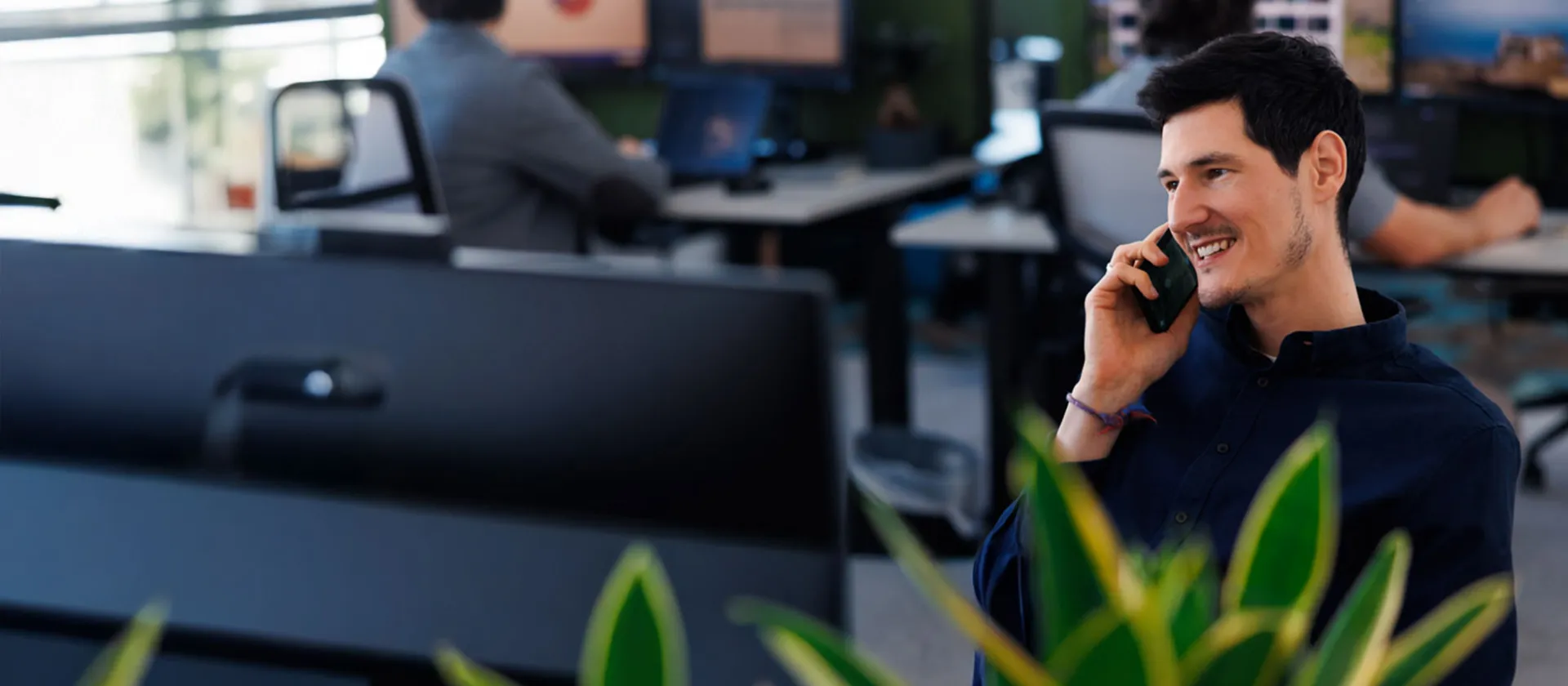 Smiling business professional on a phone call at modern msg Plaut office, collaborating on digital transformation solutions.