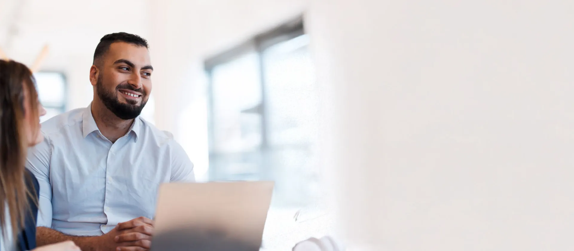 miling professional man in a meeting, discussing ideas with a colleague.