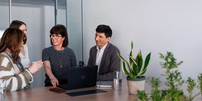 Business meeting with diverse team, discussing innovative digital solutions in a modern office setting.