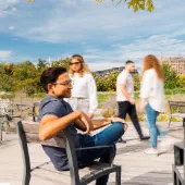Two colleagues from msg Plaut engaging in a relaxed outdoor discussion on a sunny day, with modern architecture and greenery in the background.
