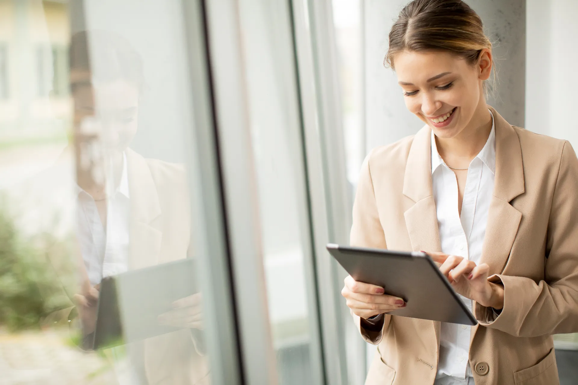 Eine Kundin unserer msg digital services blickt zufrieden auf ihr Tablet