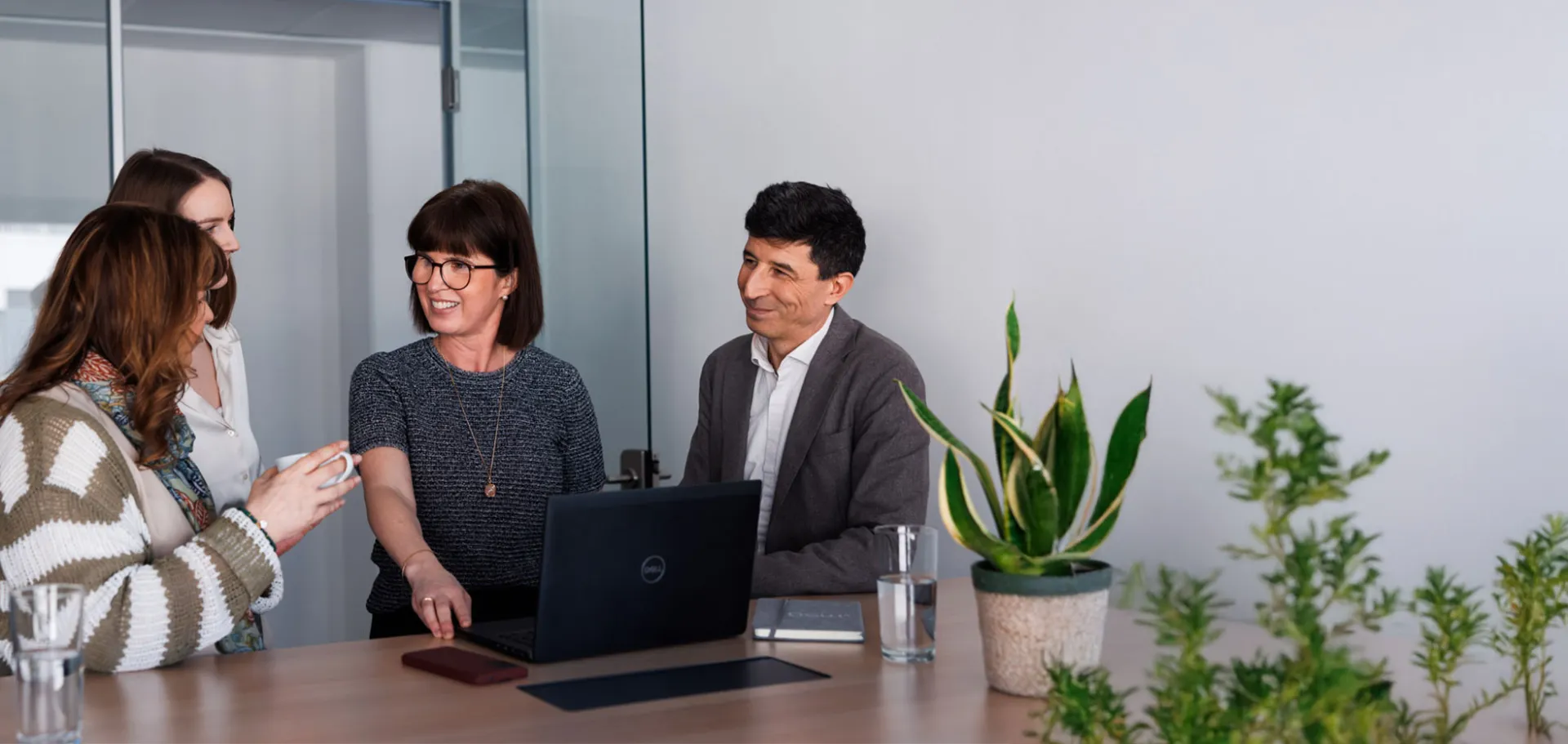 Business meeting with diverse team, discussing innovative digital solutions in a modern office setting.